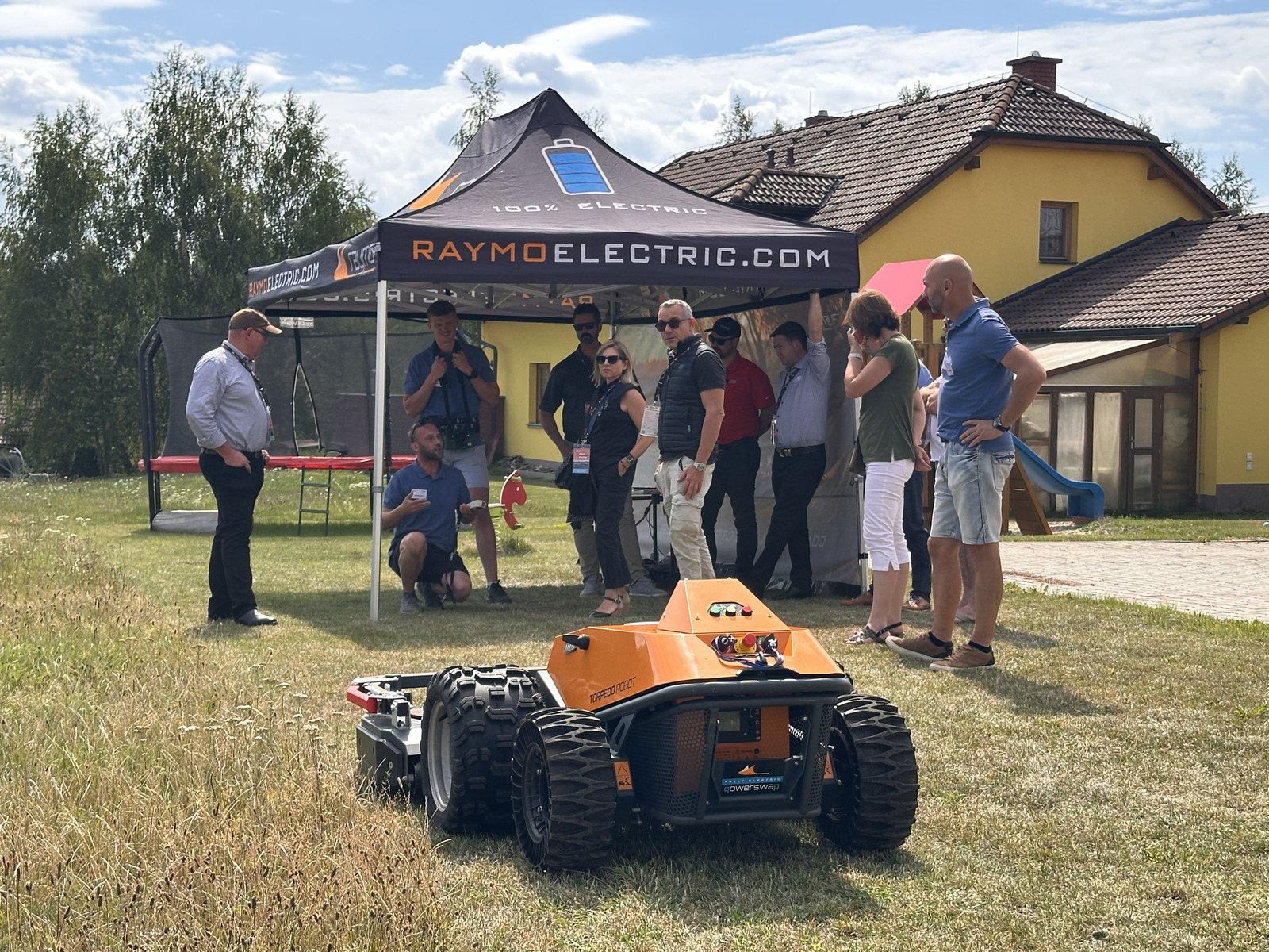 Orange Torpedo Robot in front of the Raymo Electric demo tent