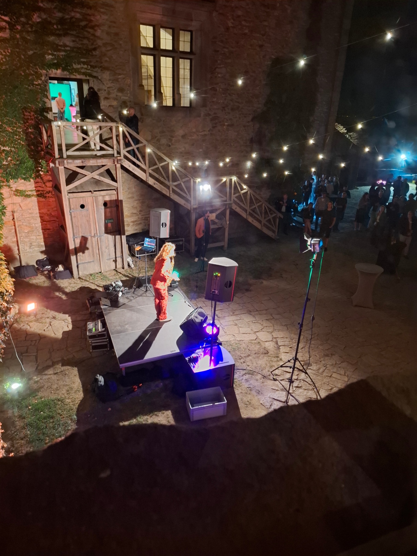Singer performing on stage in the illuminated castle courtyard