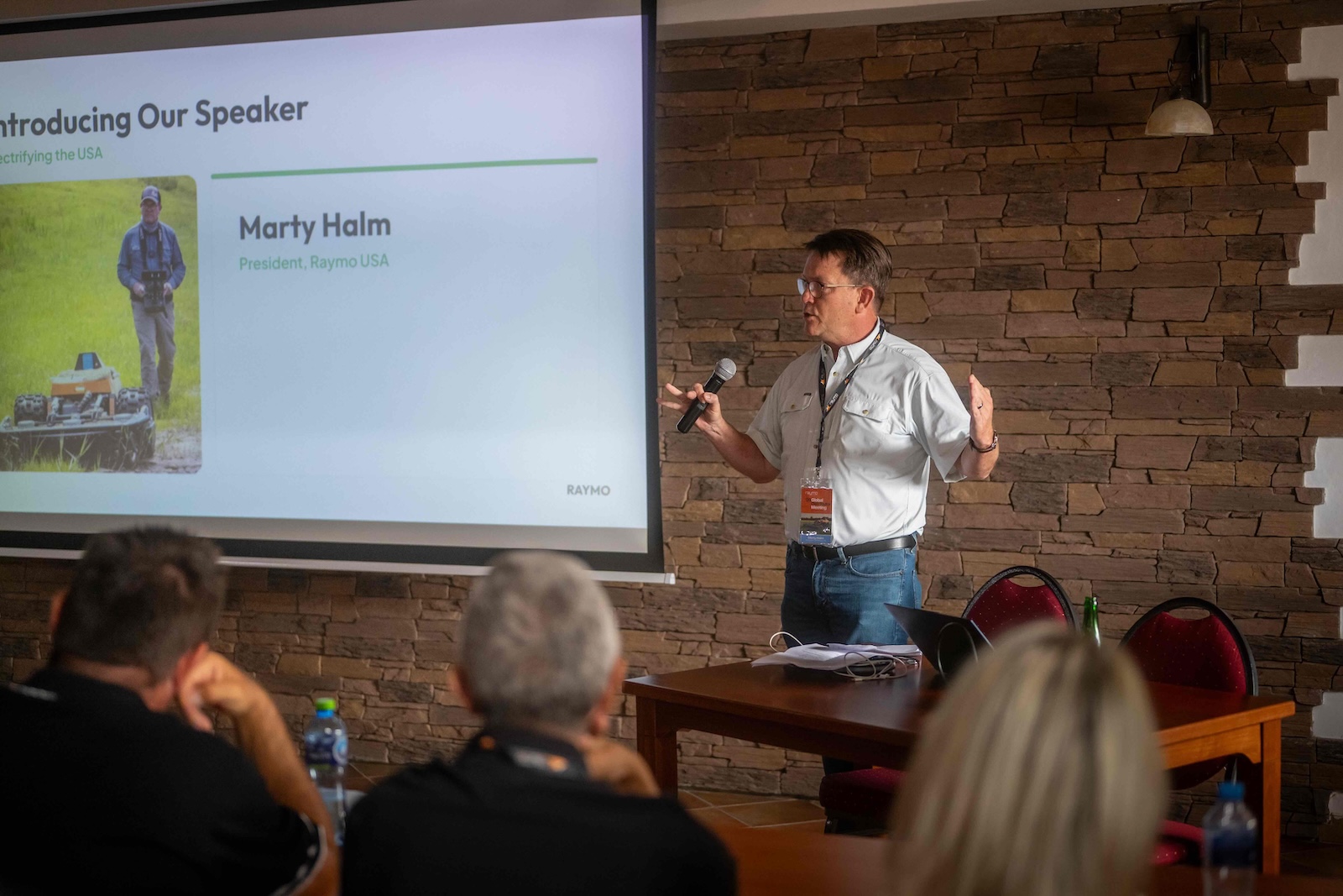 Marty Halm speaking to the audience next to his intro slide
