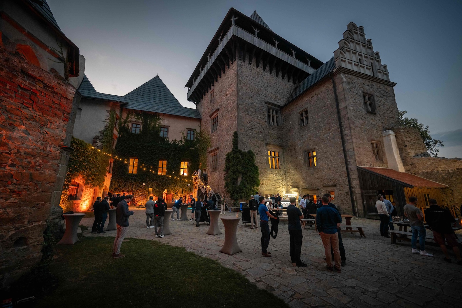 Guests gathered in the illuminated courtyard of Lipnice Castle at night
