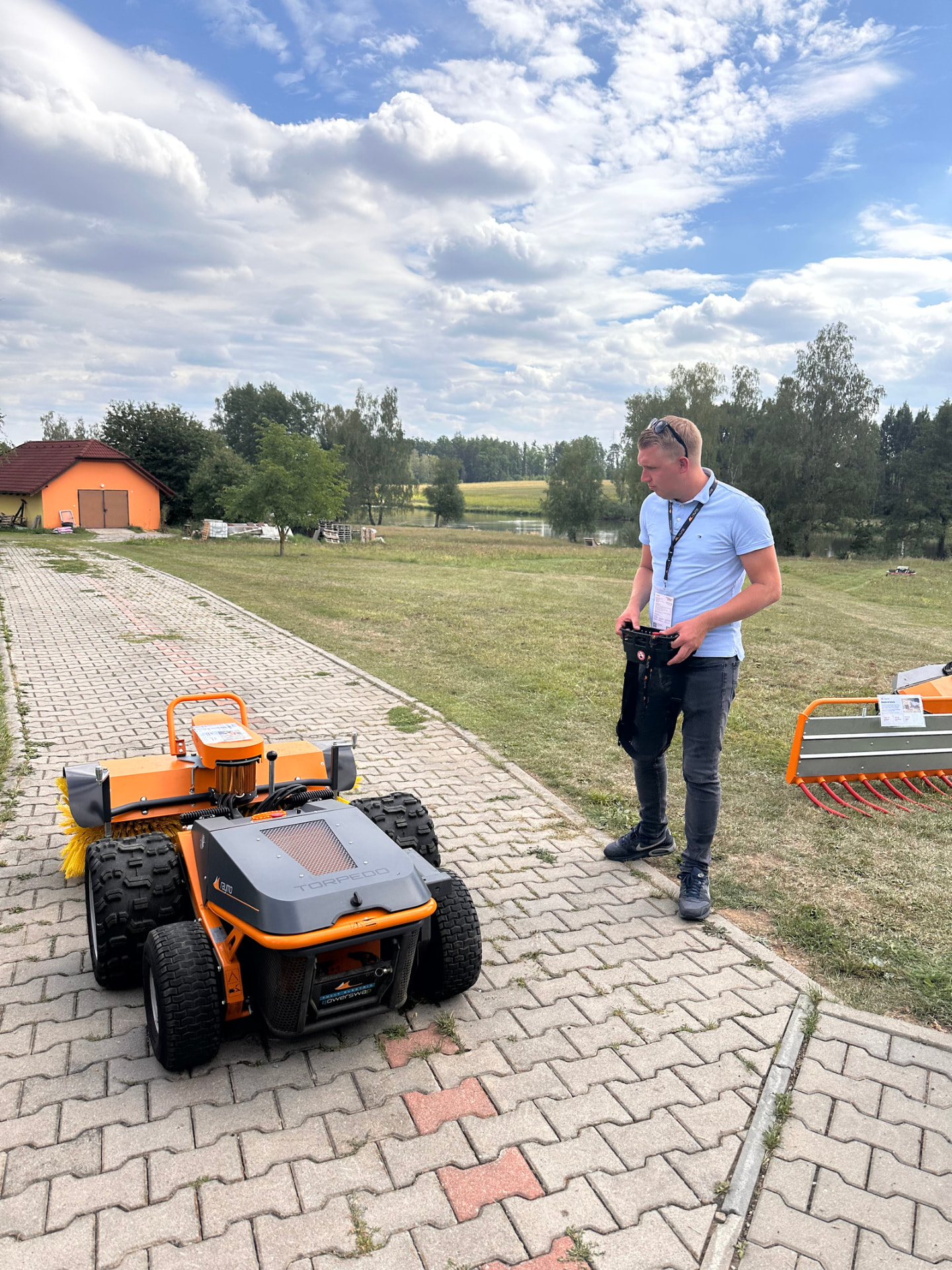 Operator controlling a Torpedo robot with a sweeper attachment