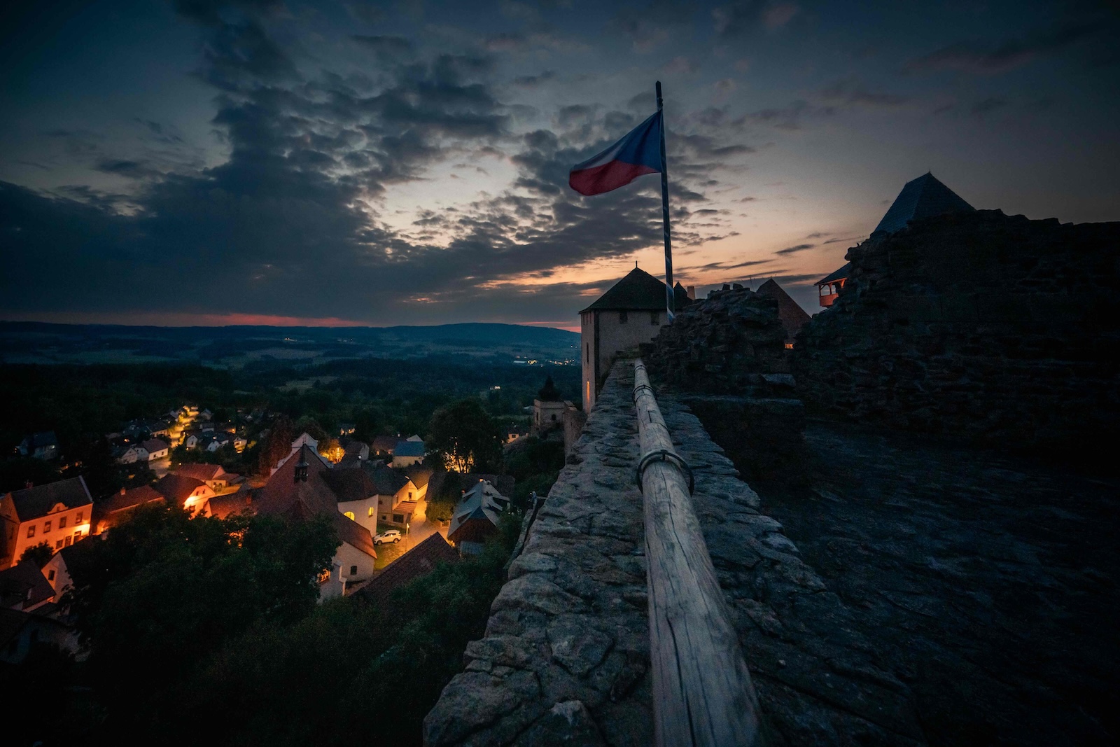 View from the castle walls over Lipnice village at dusk with the Czech flag