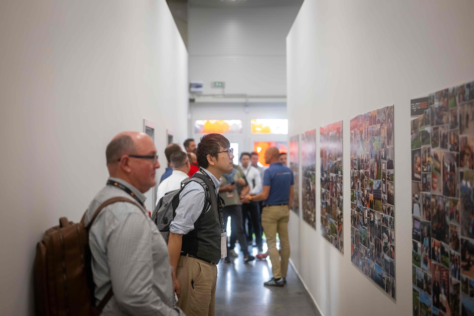 Guests viewing the Raymo photo wall exhibition in the corridor