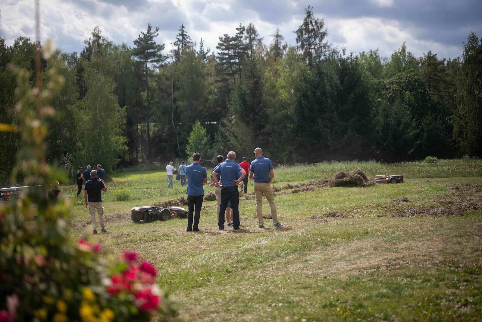 Raymo Mowers team watching robots work across the meadow