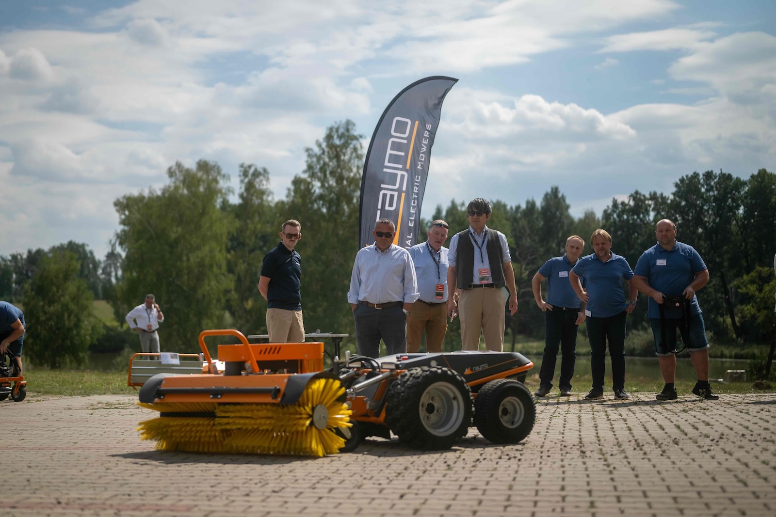 Distributors watching the sweeper attachment demo in front of the Raymo flag