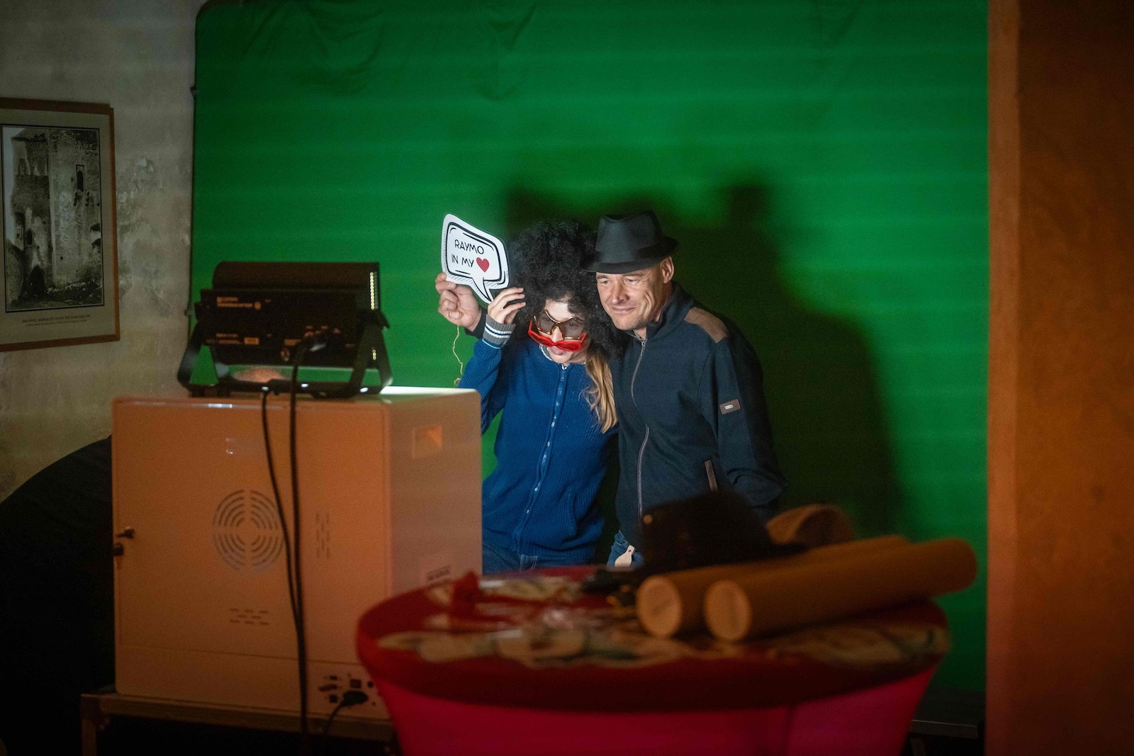 Guests posing with props in the green screen photo booth