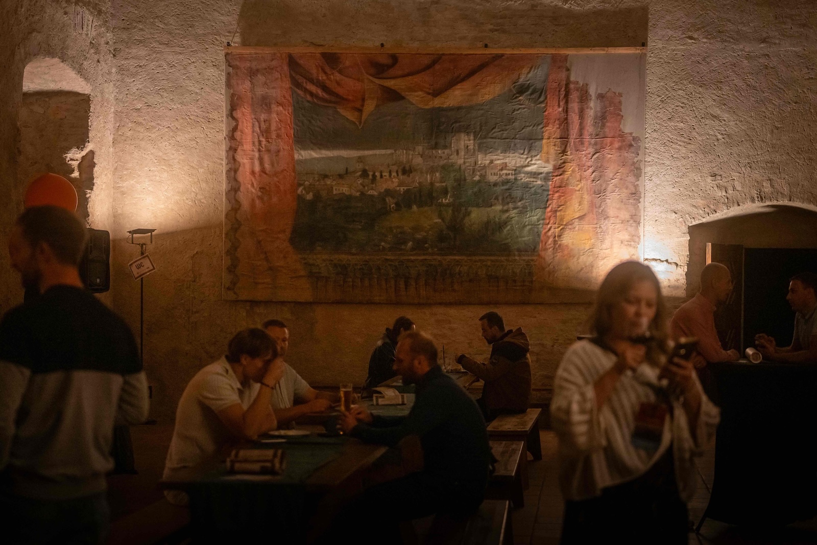 Guests at wooden tables in the vaulted castle hall