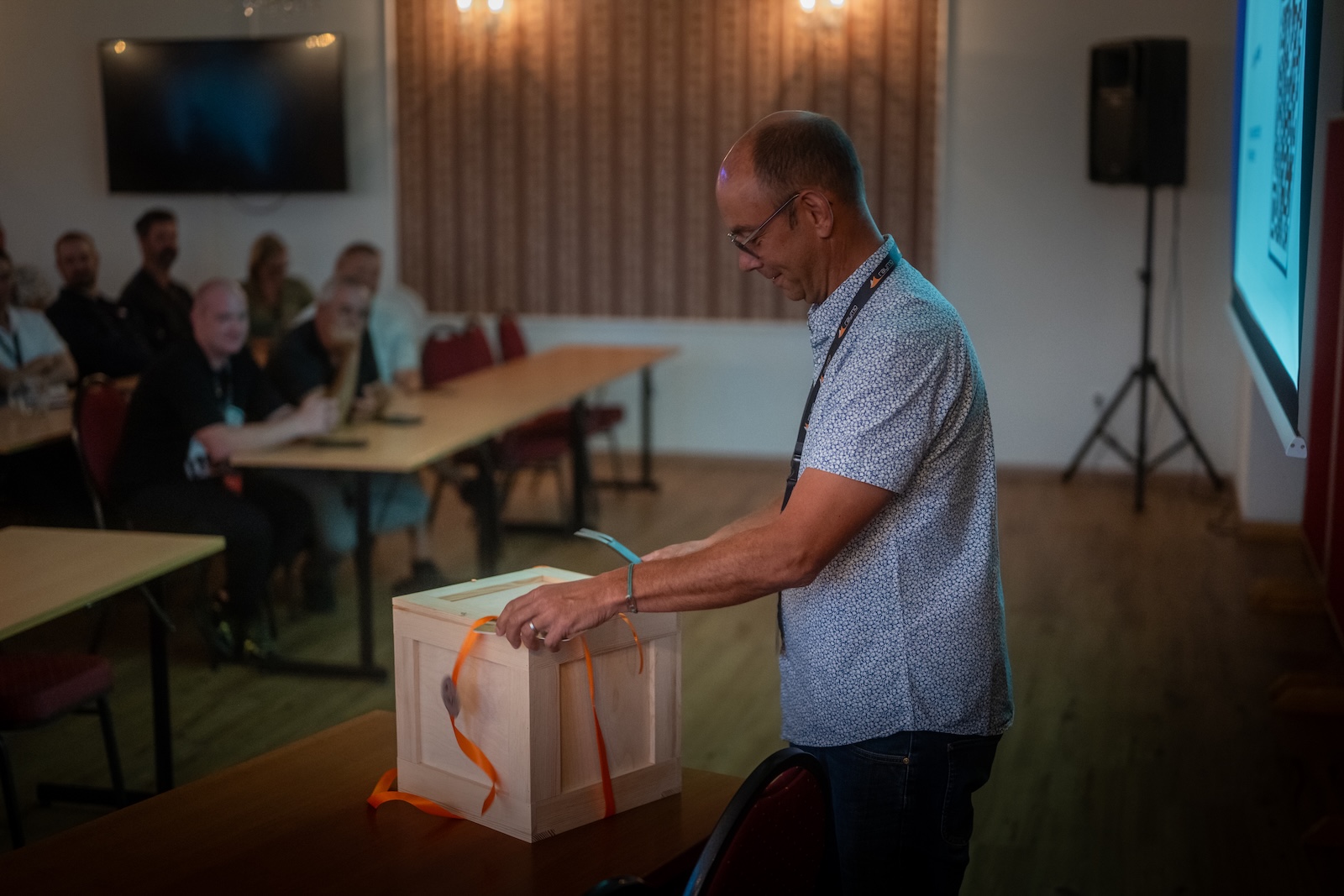 Presenter opening the wooden feedback box in the conference room