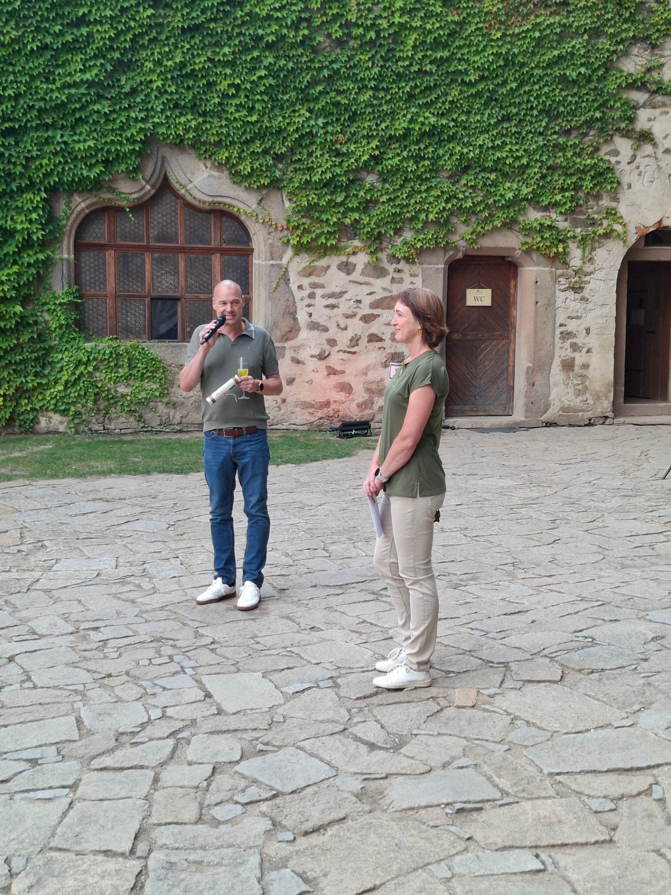 Hosts welcoming guests with a microphone in the castle courtyard