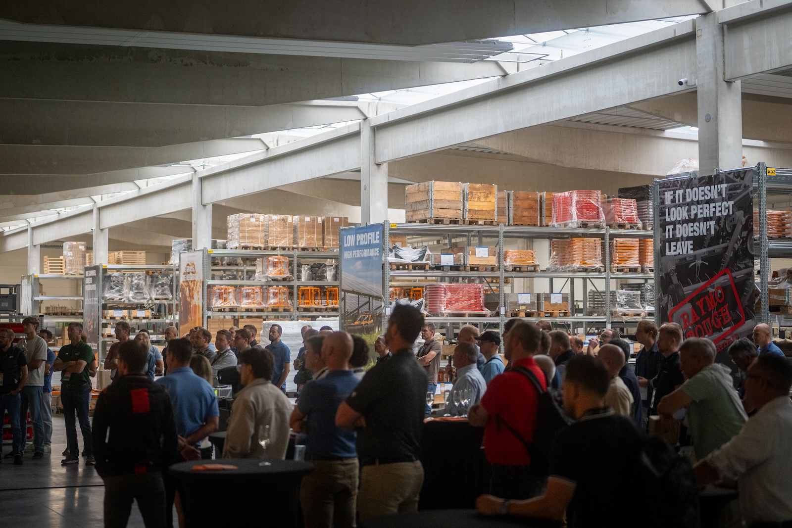 Crowd of distributors in the parts warehouse among Raymo banners