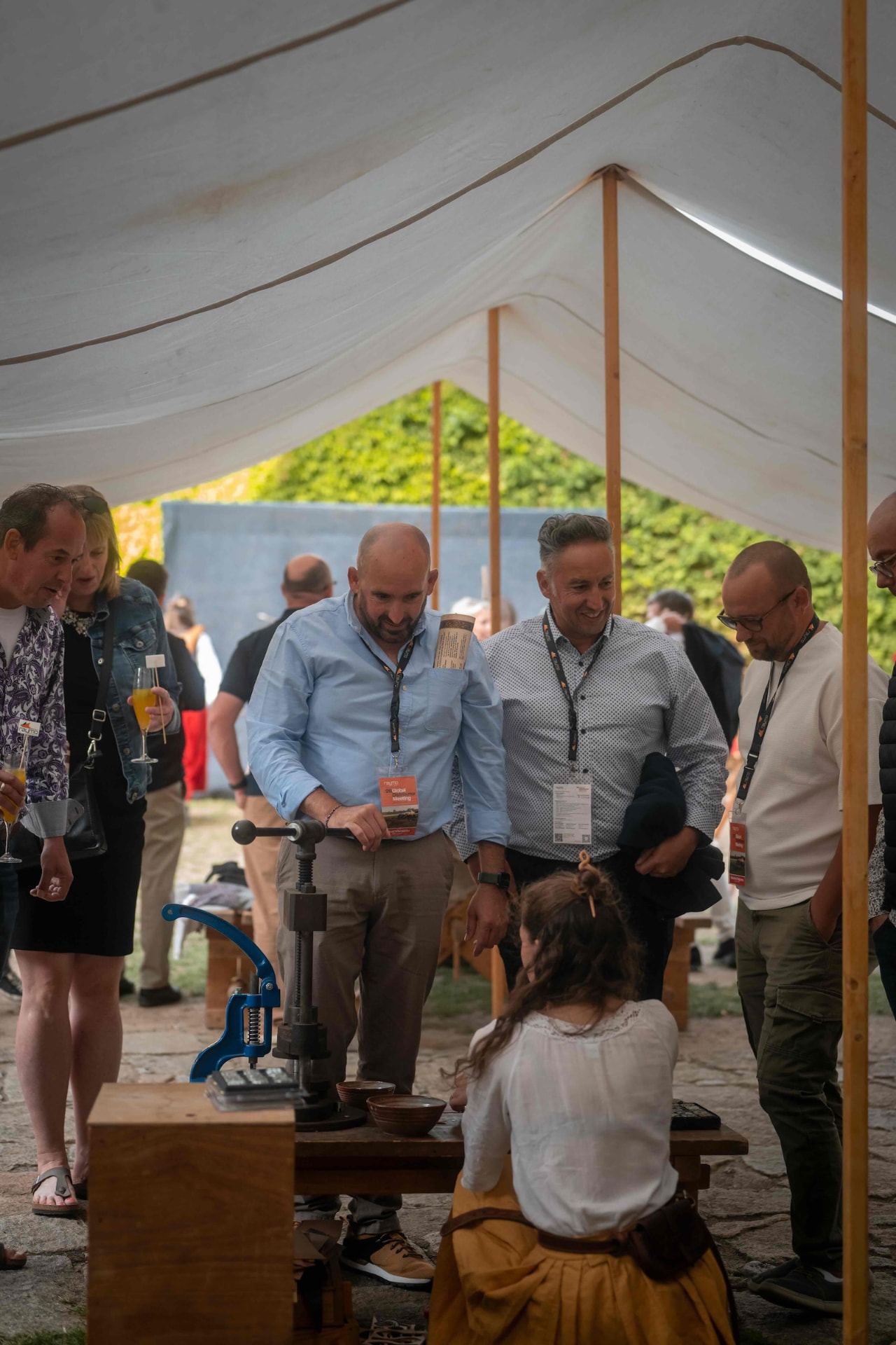Guests watching a craftswoman work at the historic workshop tent