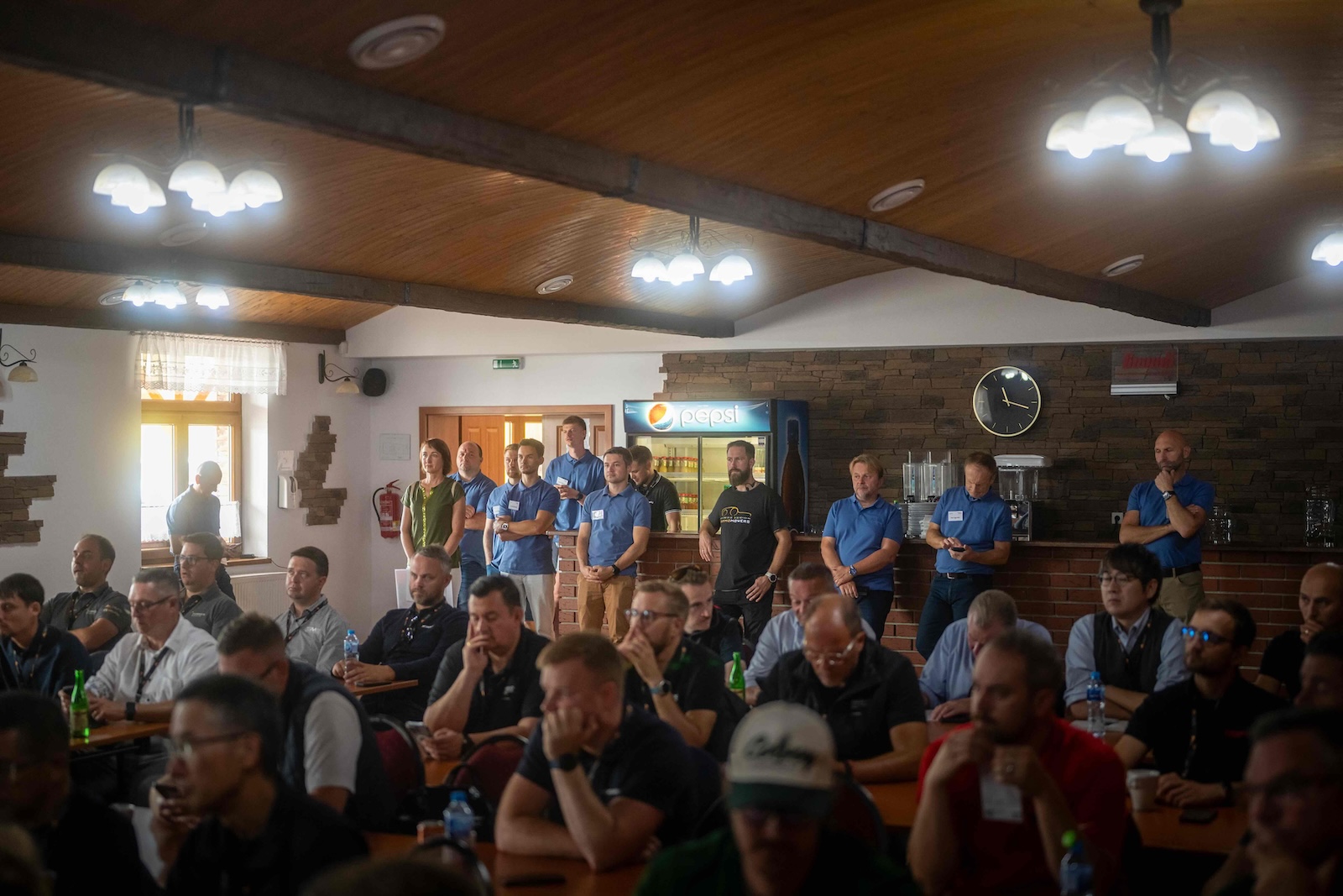 Wide view of the packed conference room with the Raymo team standing at the bar