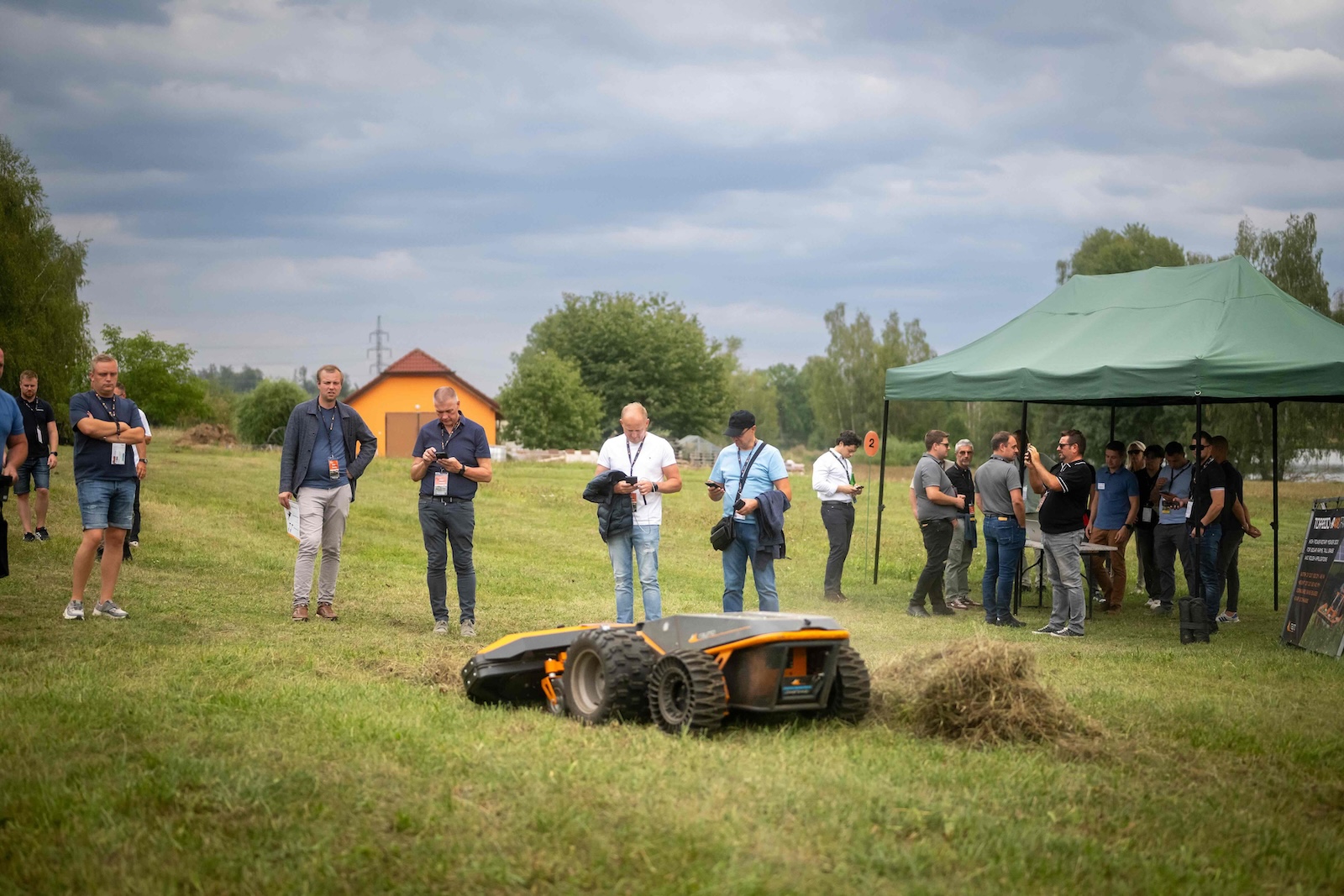 Distributors watching a Torpedo robot mow at demo station 2