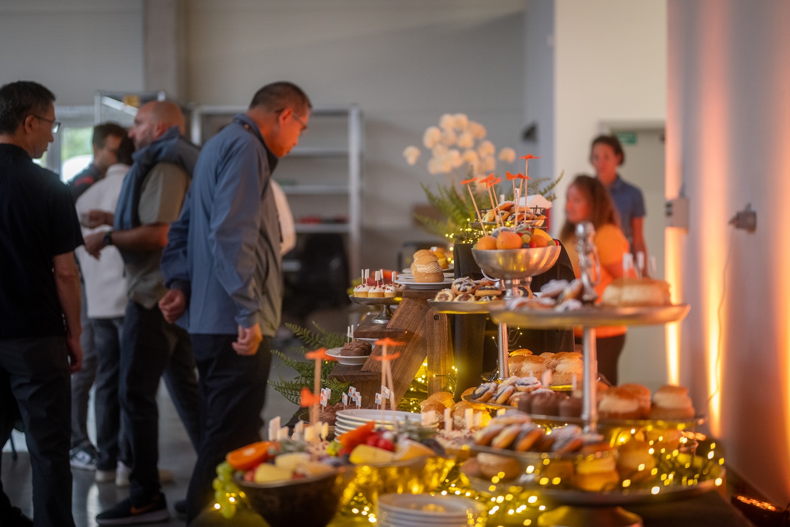 Guests at the illuminated buffet table with desserts