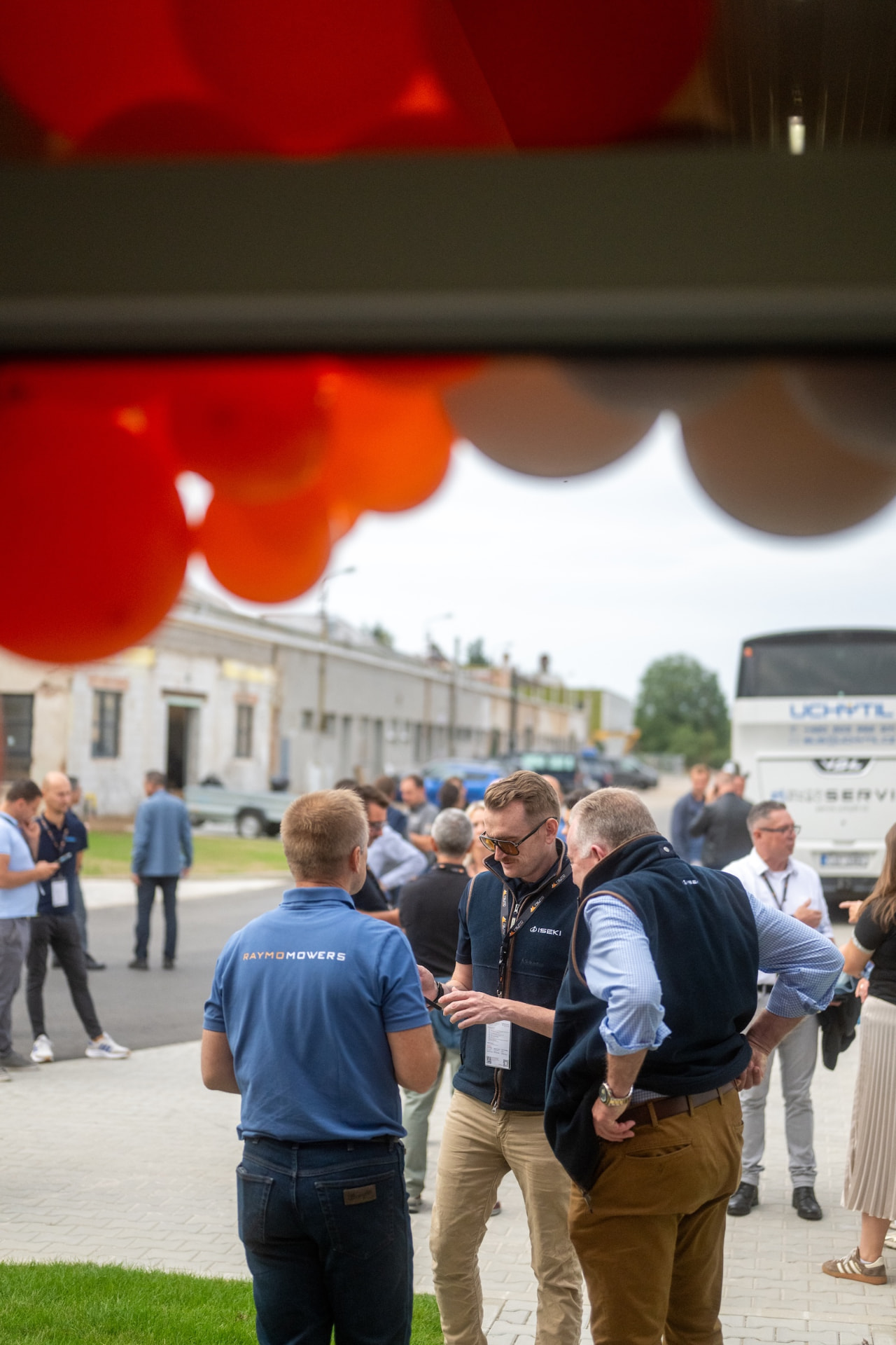 Distributors talking outside under the orange balloon arch