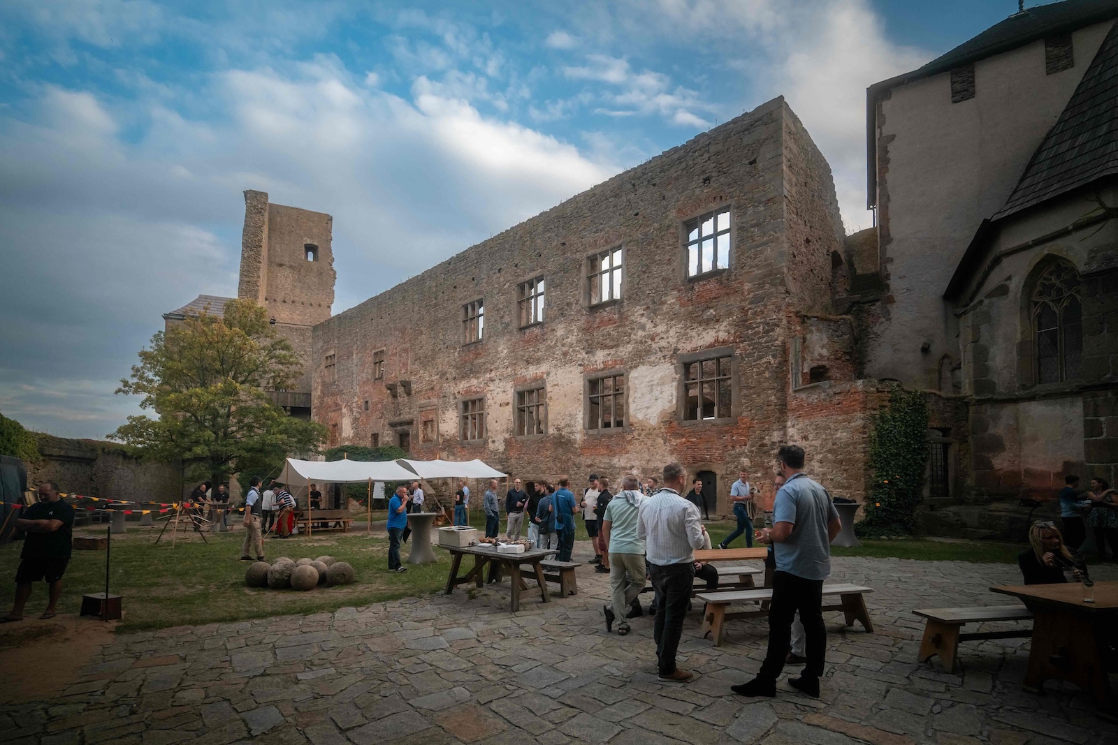 Attendees gathered in the castle courtyard by the ruined palace wall