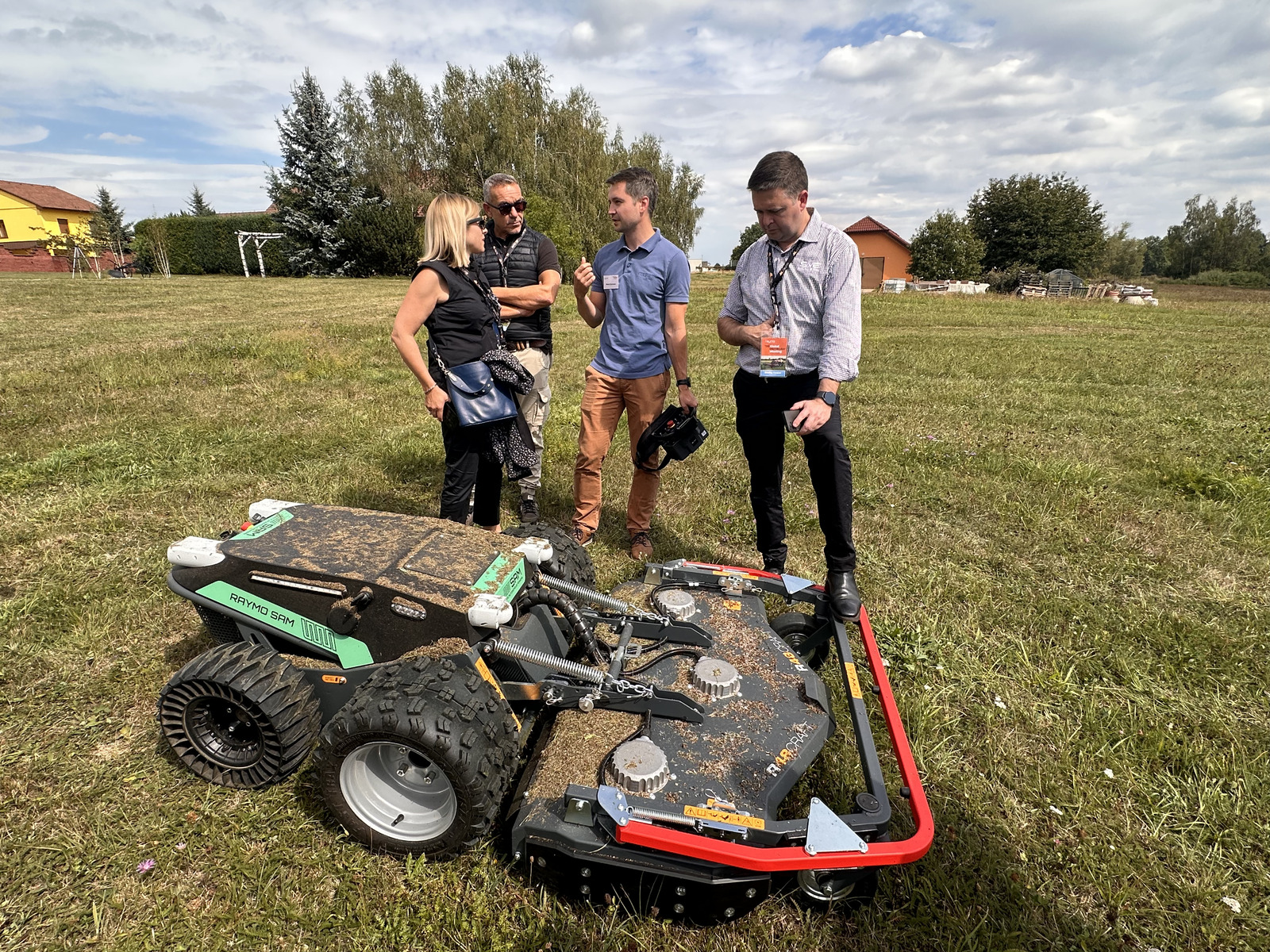 Guests discussing the Raymo SAM autonomous mower