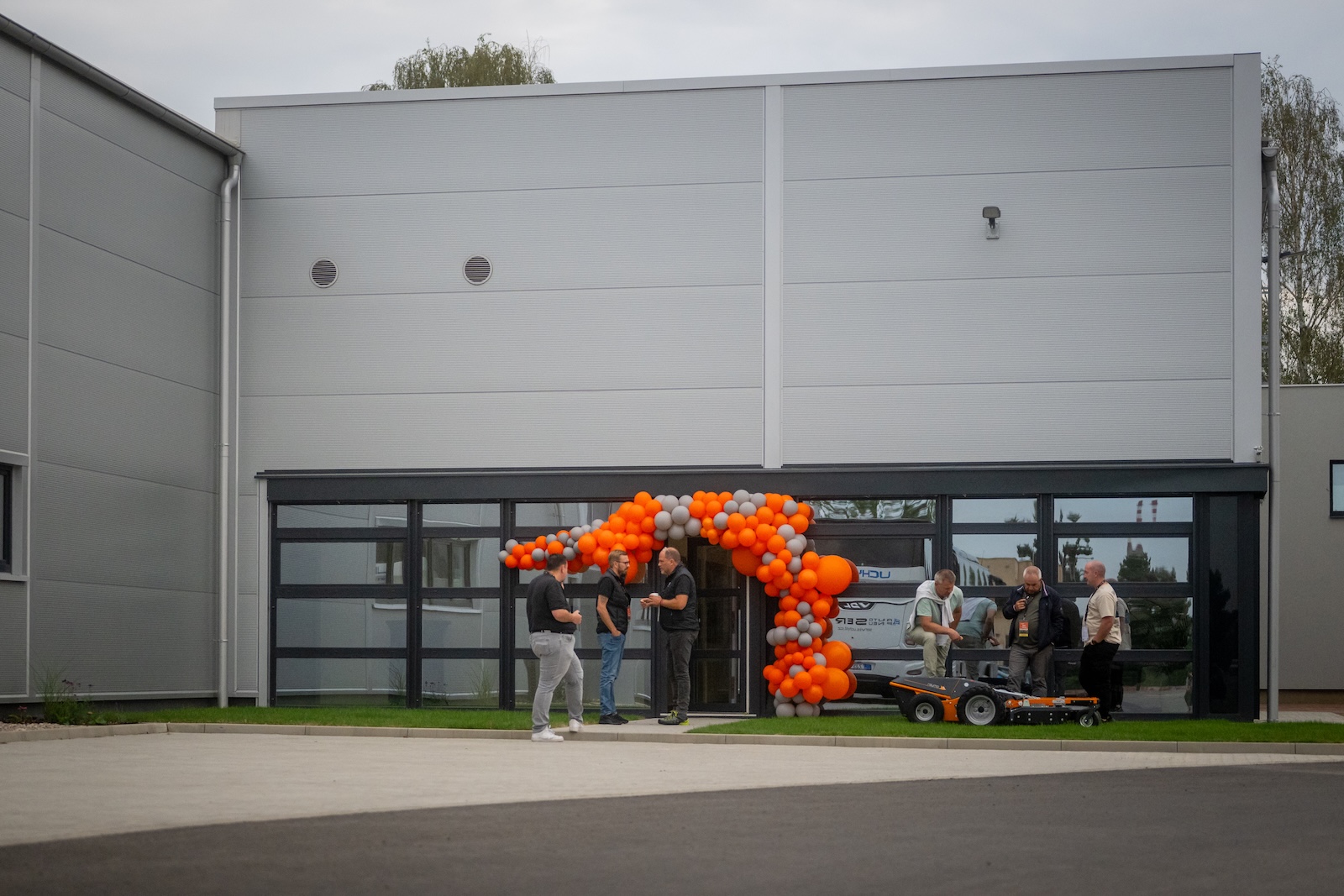 Guests in front of the new Raymo hall with an orange balloon arch