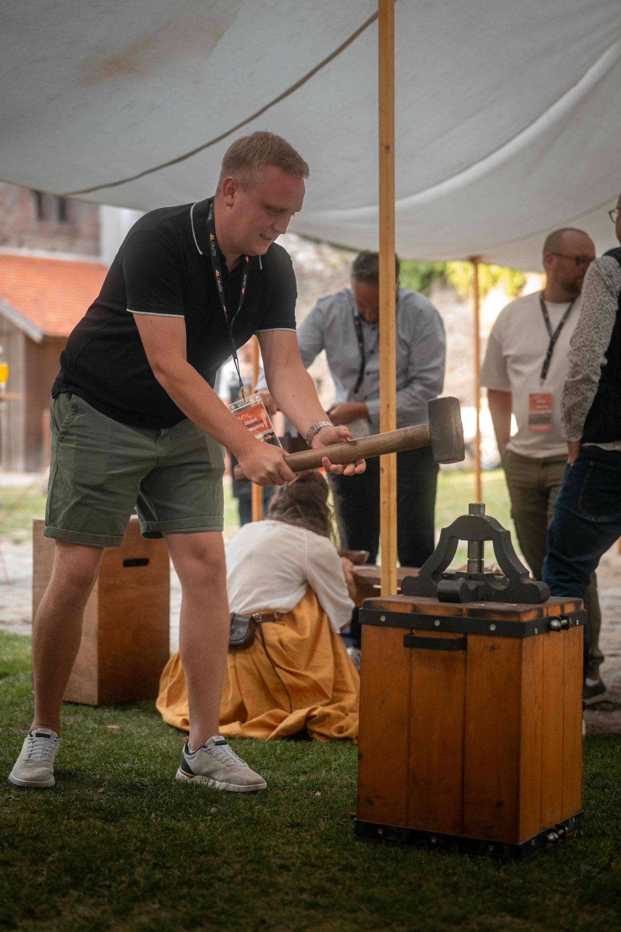 Attendee striking a stamp with a wooden mallet at the craft station