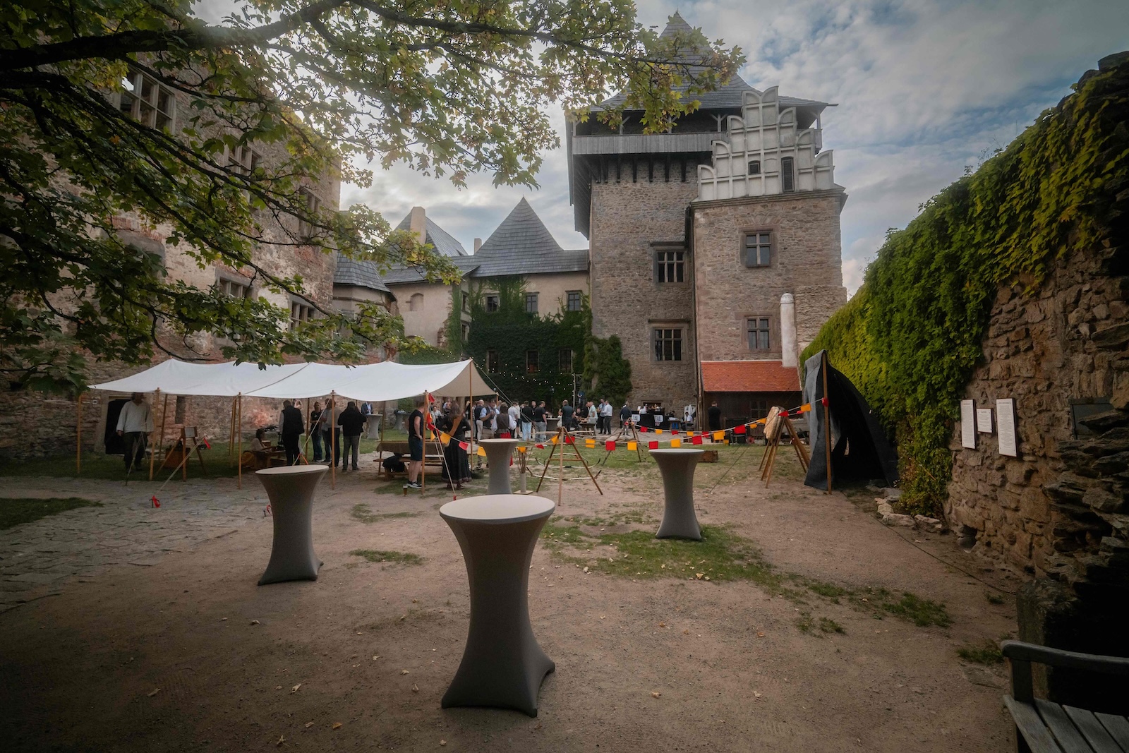 Castle courtyard with tents, cocktail tables and the tower behind