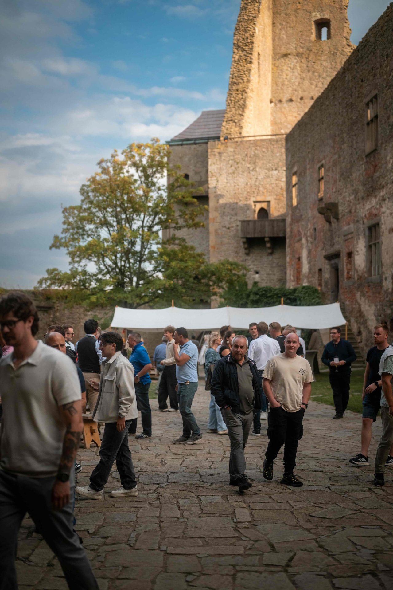 Attendees walking across the stone courtyard of Lipnice Castle