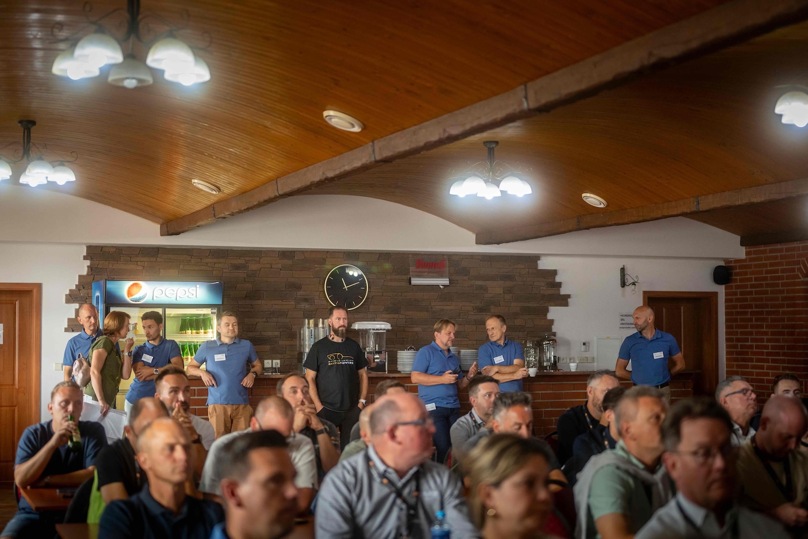 Raymo team standing at the back of the full conference room