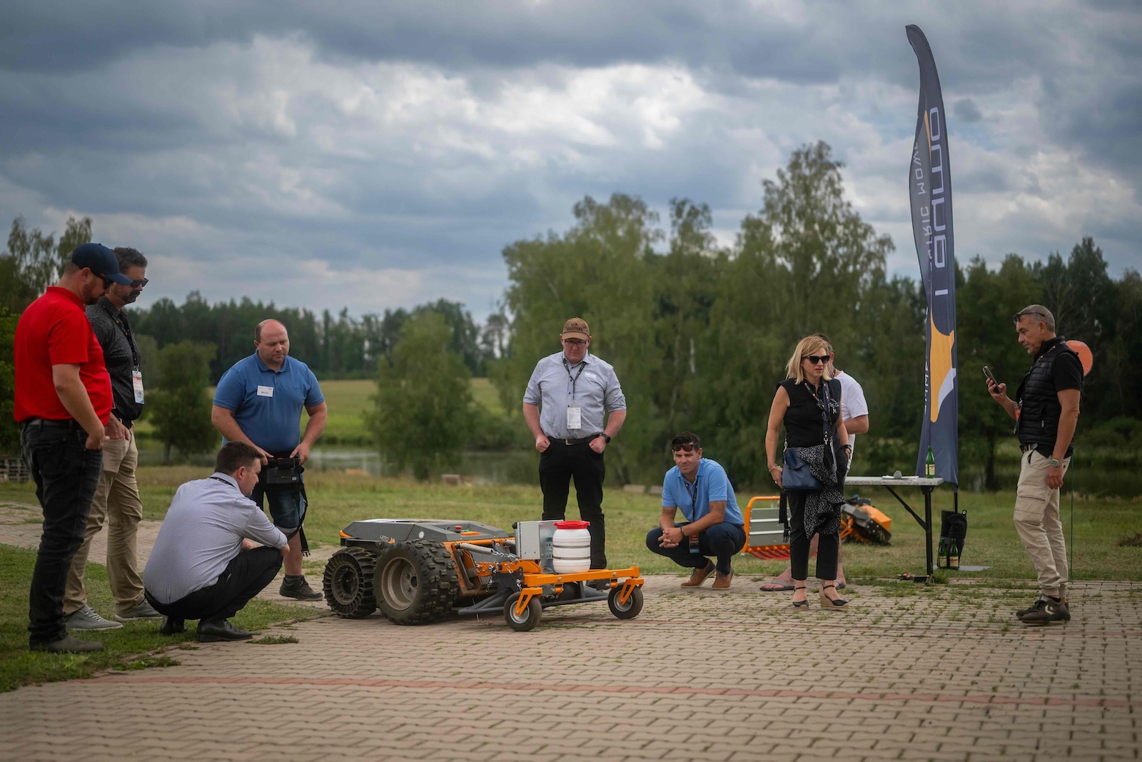 Group watching a Raymo carrier with spraying attachment on the paved area