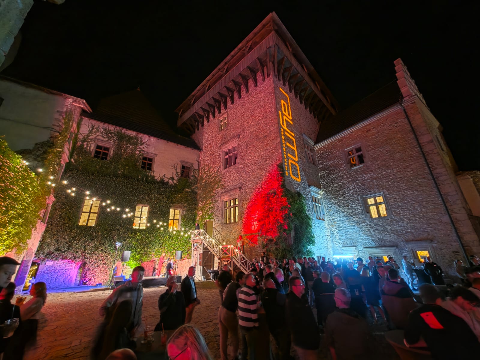 Crowd of distributors in the castle courtyard with red and orange lighting