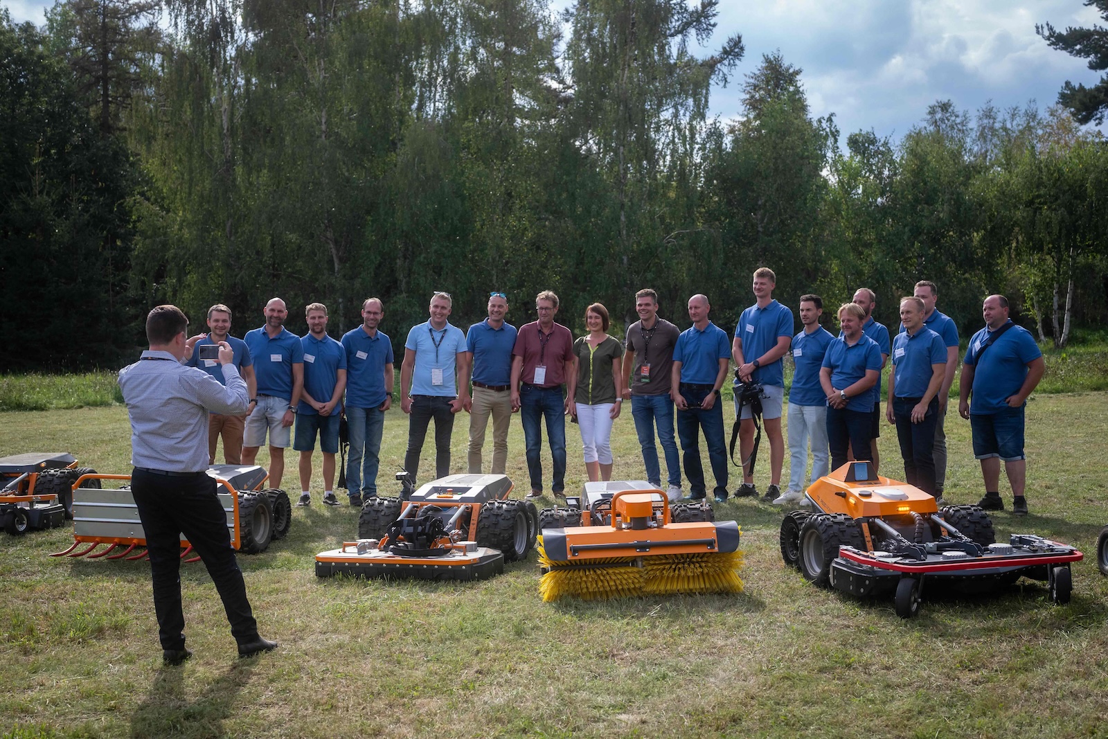 Raymo team group photo being taken behind the line-up of robots and attachments