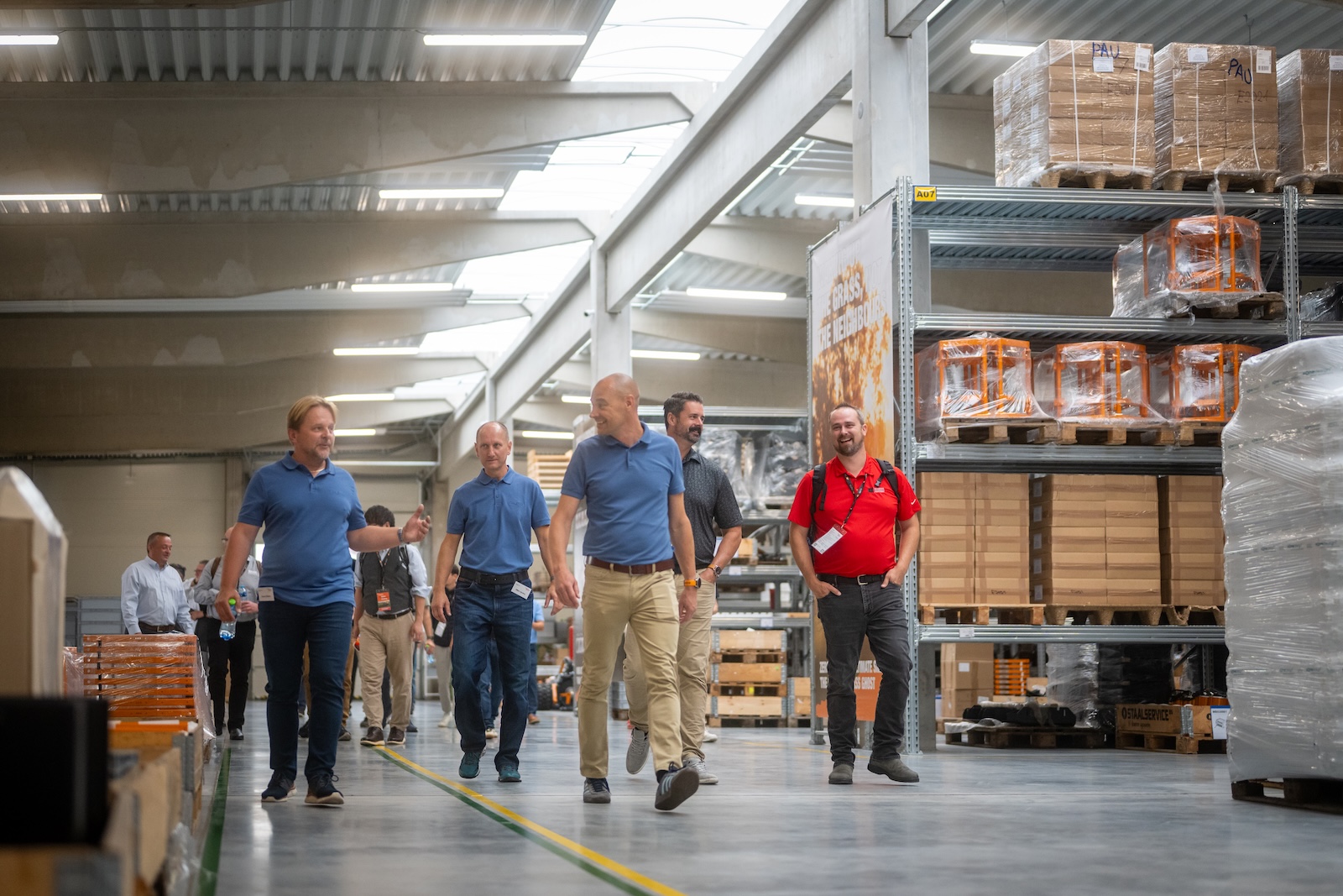 Raymo hosts walking through the warehouse aisle during the tour