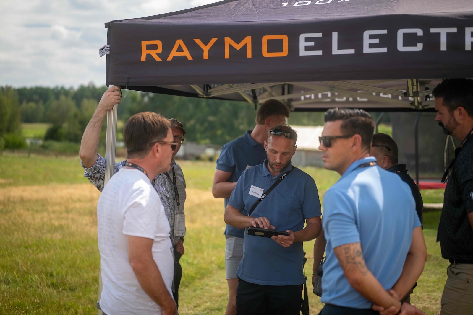 Raymo specialist showing tablet data to distributors under the tent