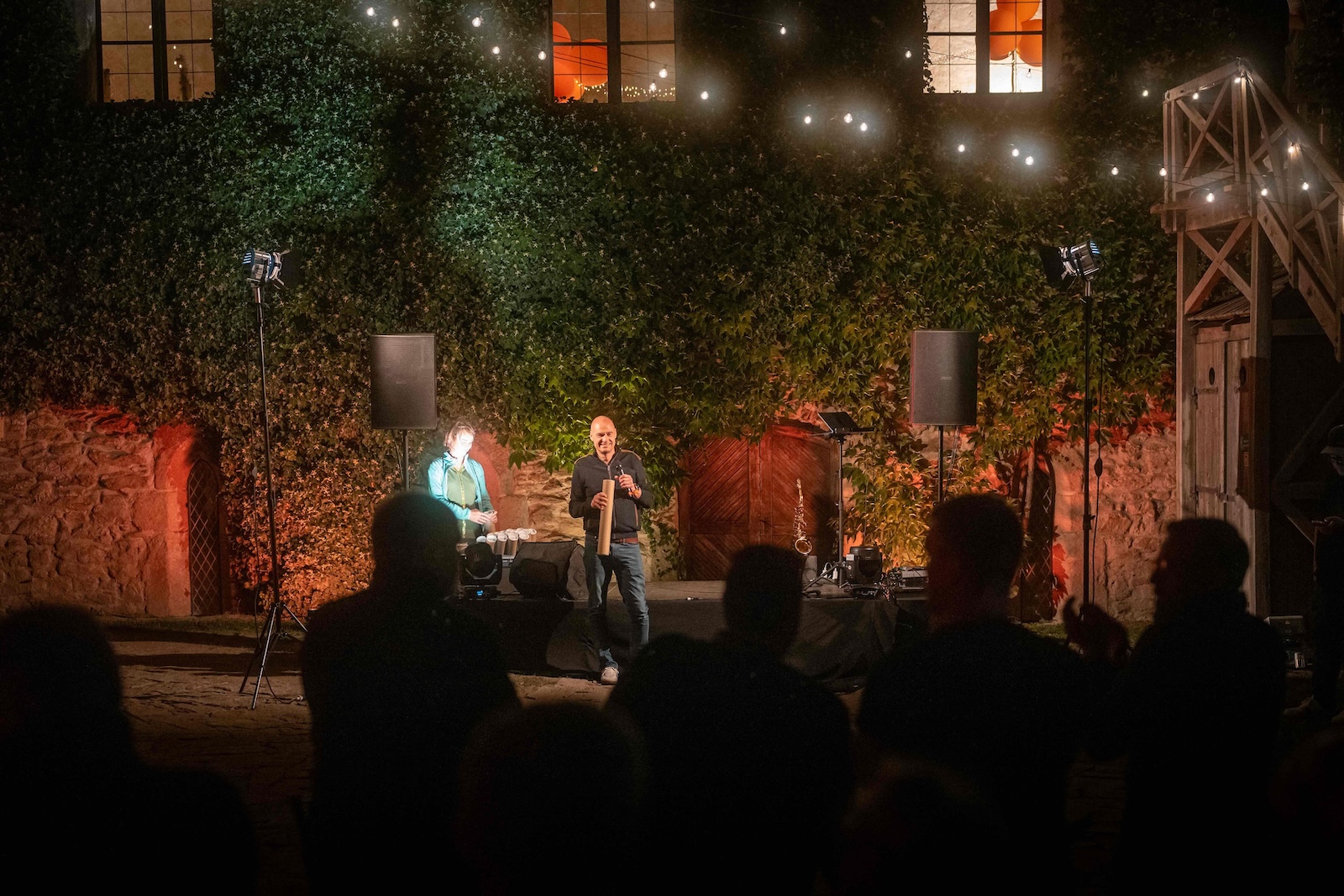Hosts on stage handing over a gift in the castle courtyard
