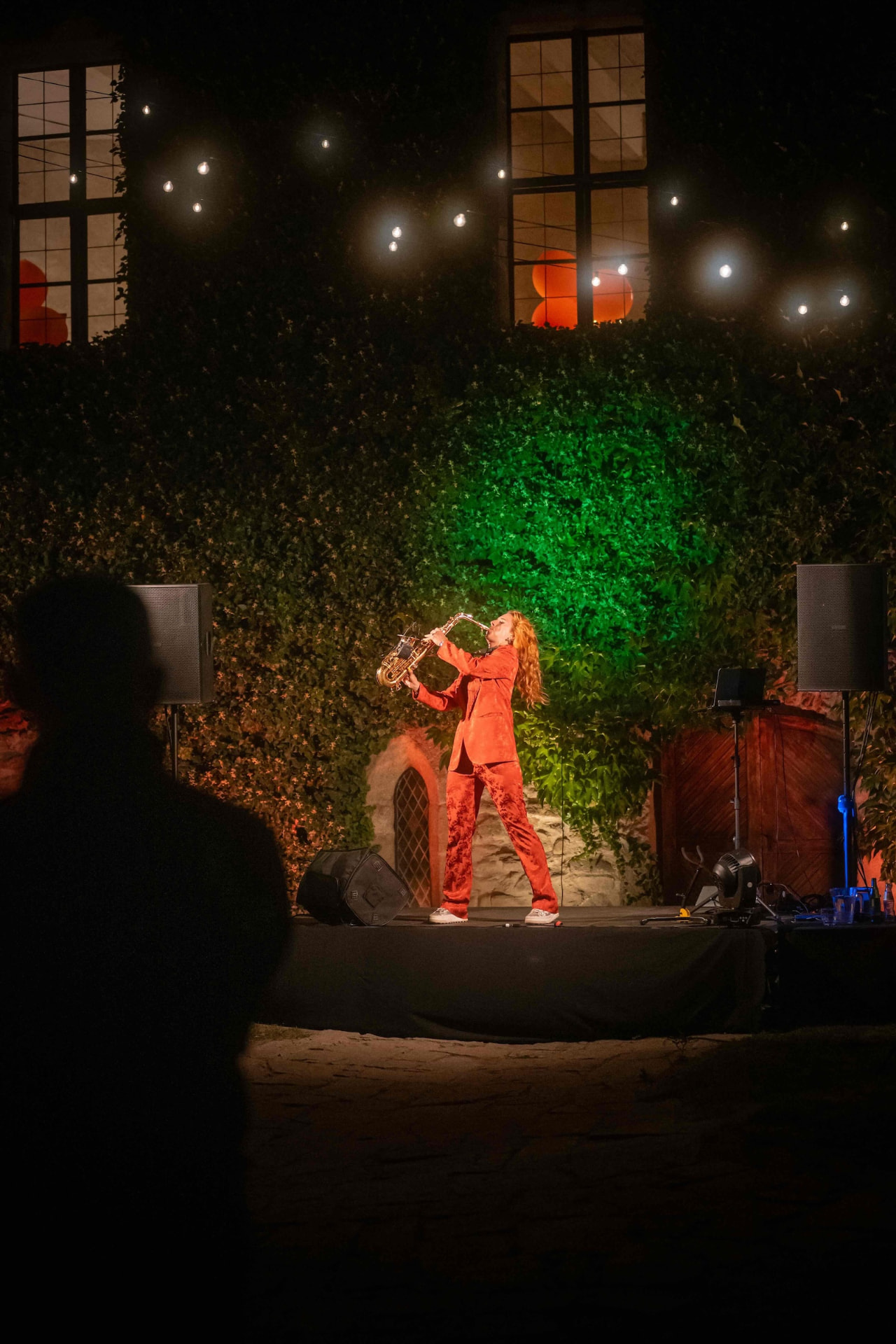 Saxophonist on the courtyard stage lit in green