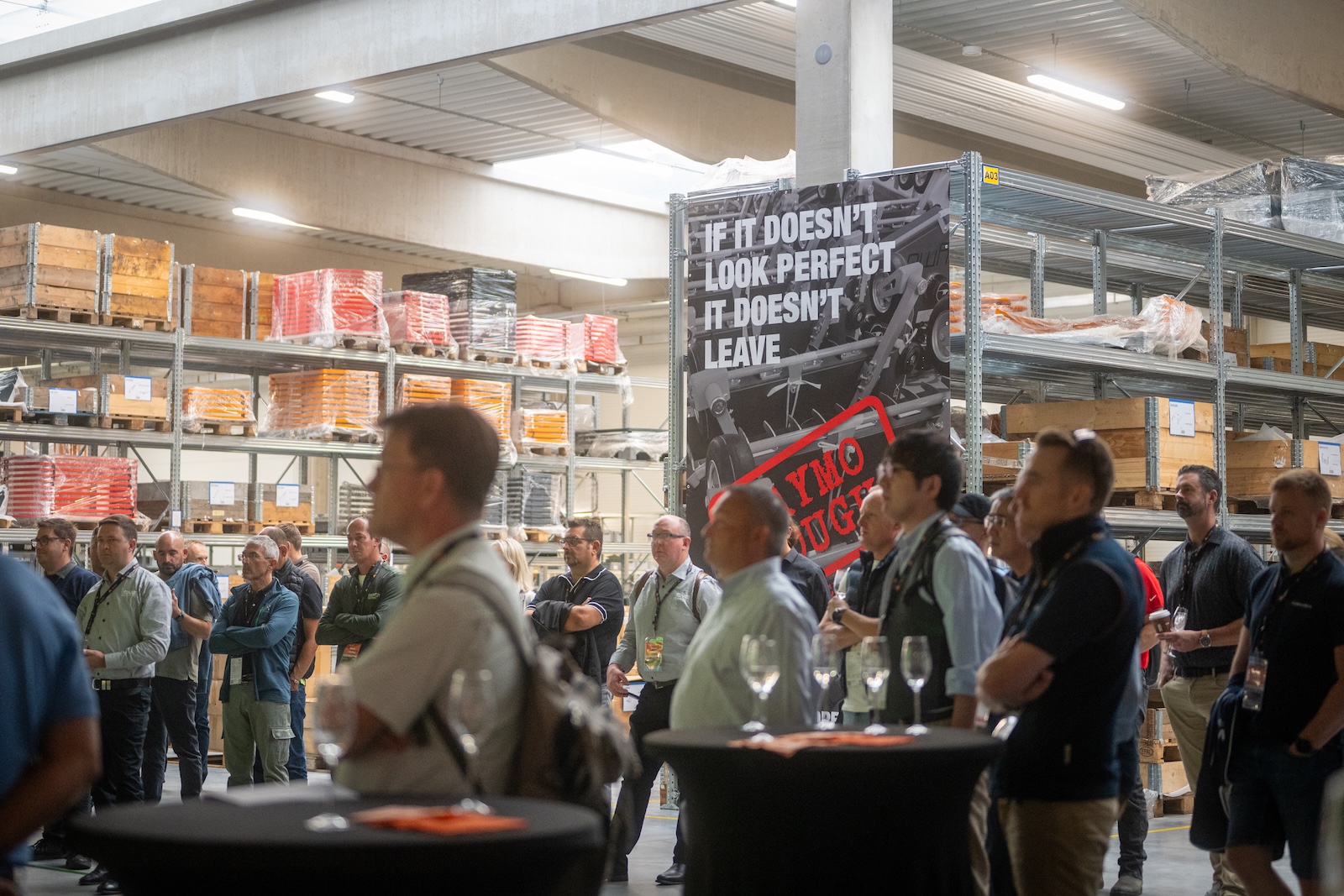 Distributors listening in the warehouse next to the Raymo Tough banner