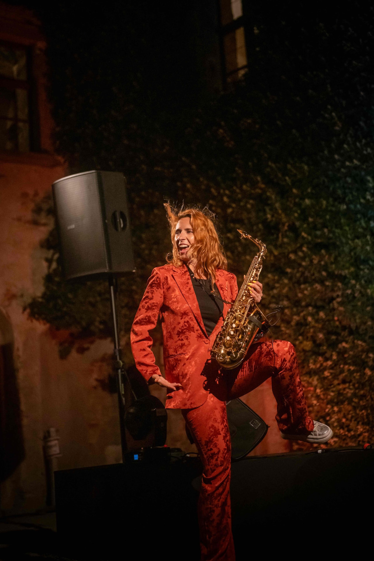 Saxophonist in a red suit posing on stage