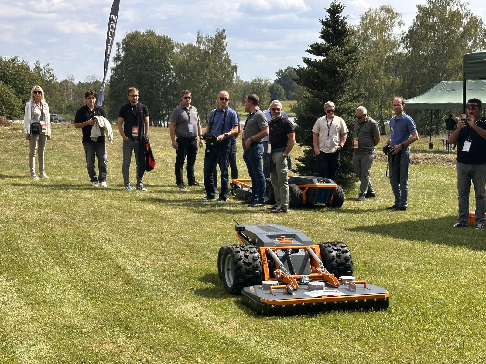 Distributors watching a remote-controlled Raymo mower on the lawn