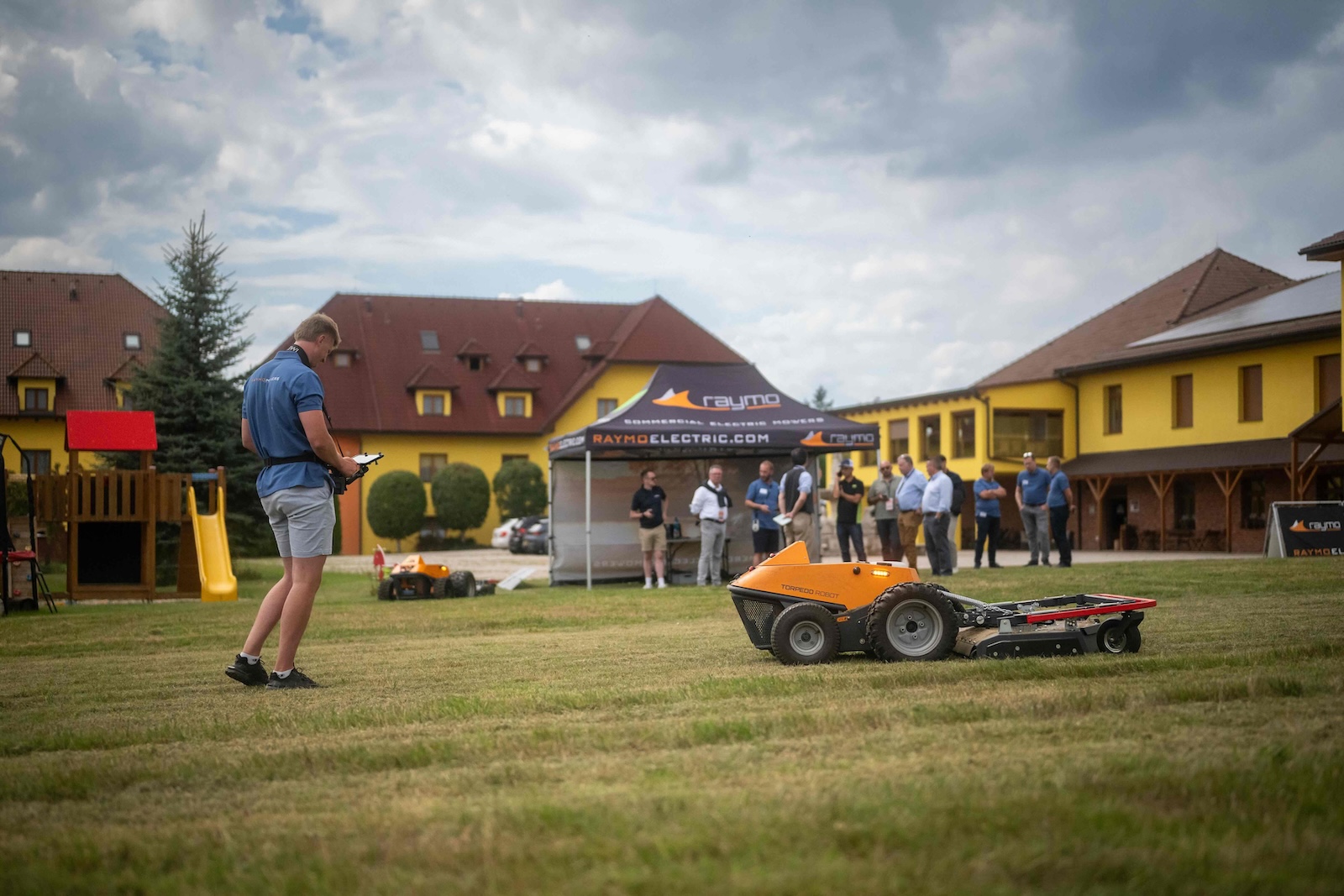 Operator controlling a Torpedo robot on the lawn in front of the Raymo tent
