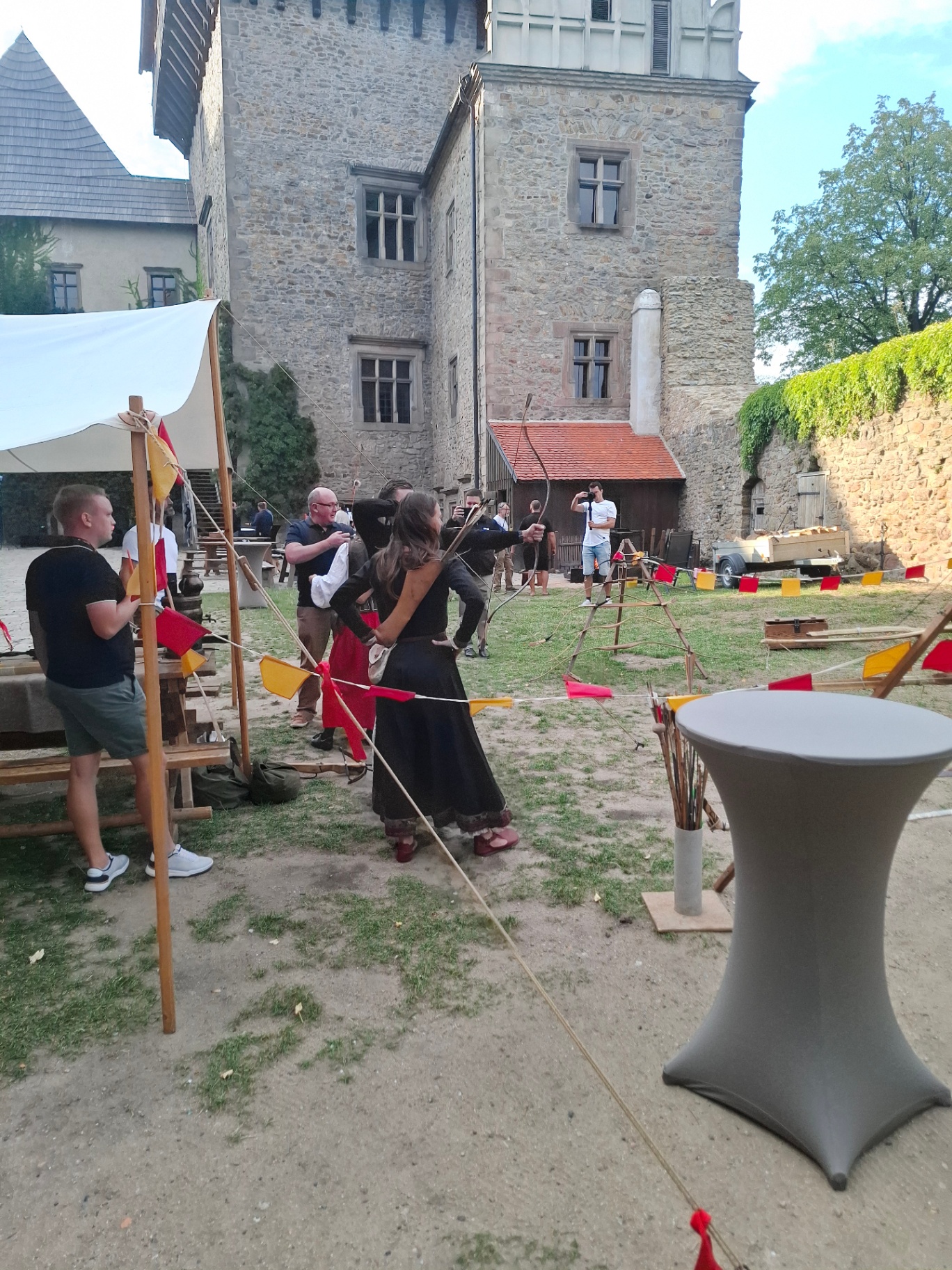 Guests shooting bows at the archery range below the castle tower