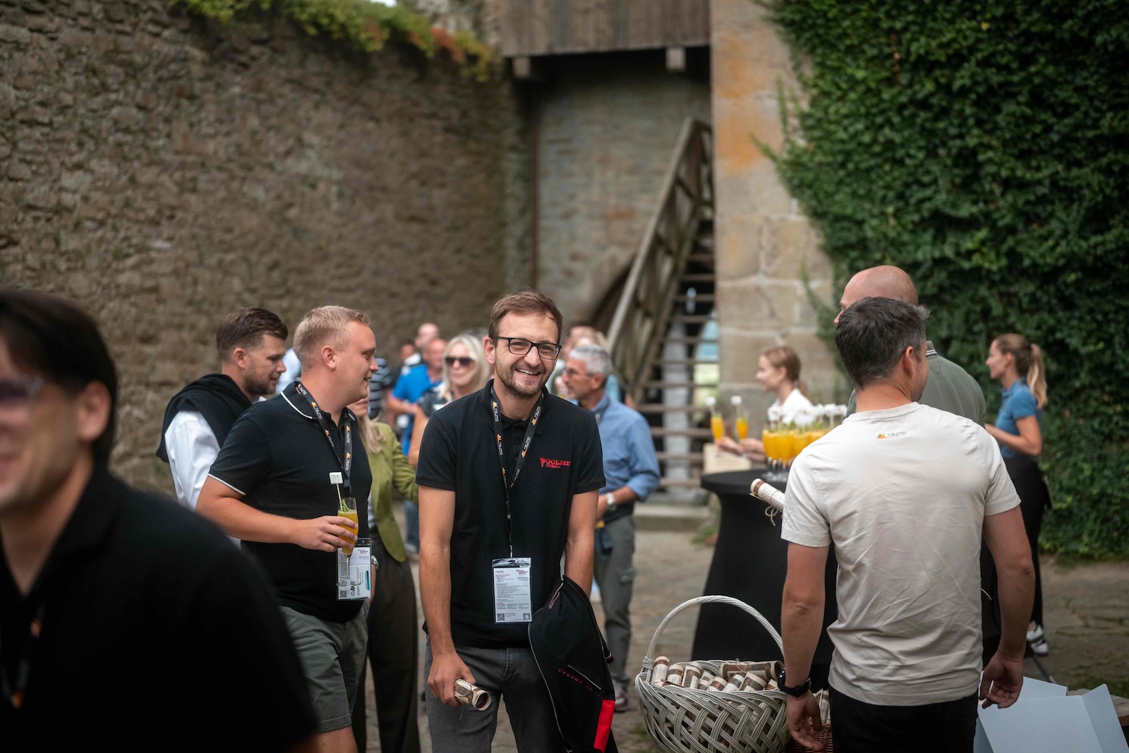 Smiling guests with drinks in the courtyard of Lipnice Castle