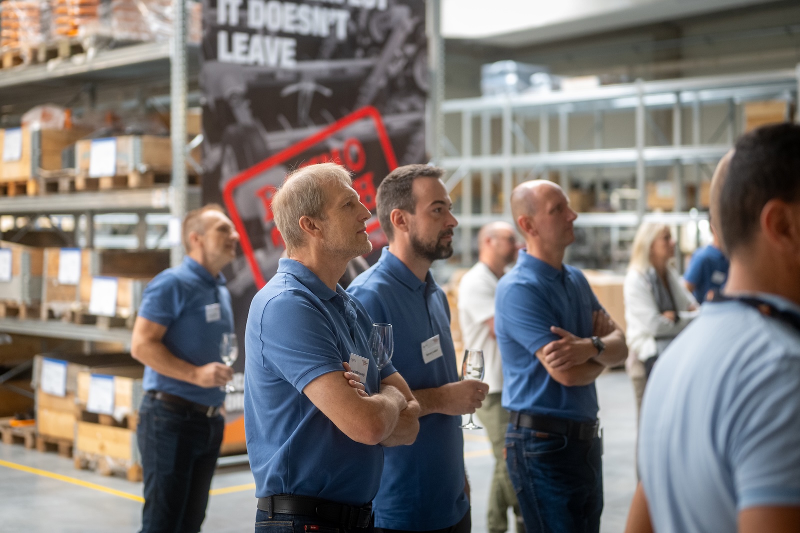 Raymo staff in blue polo shirts watching the presentation