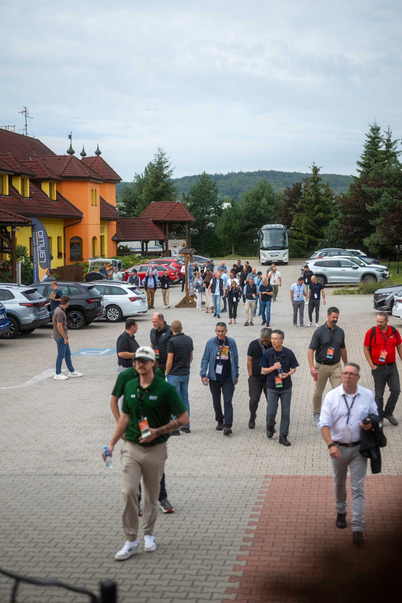 Attendees walking to Hotel Tri Vezicky from the coaches